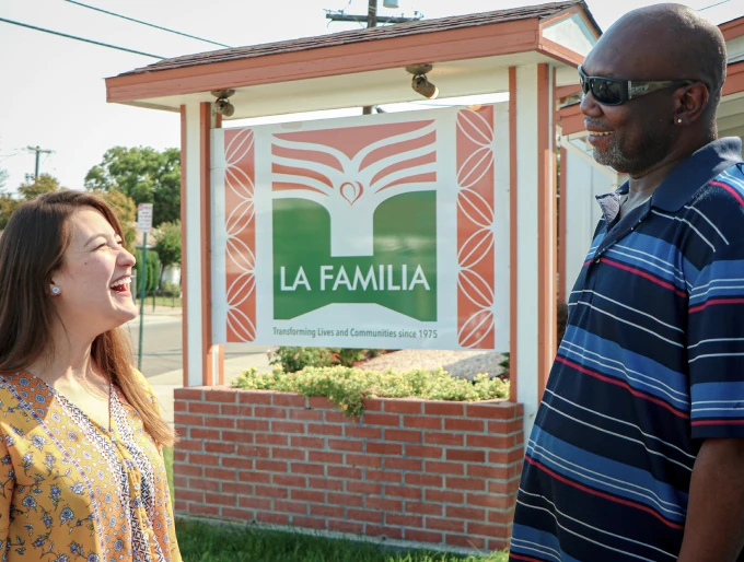 La Familia woman and man talking